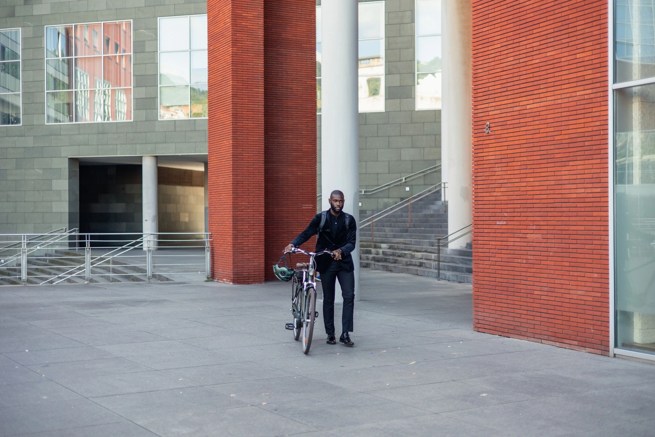 Person walking with an electric bike in an urban area