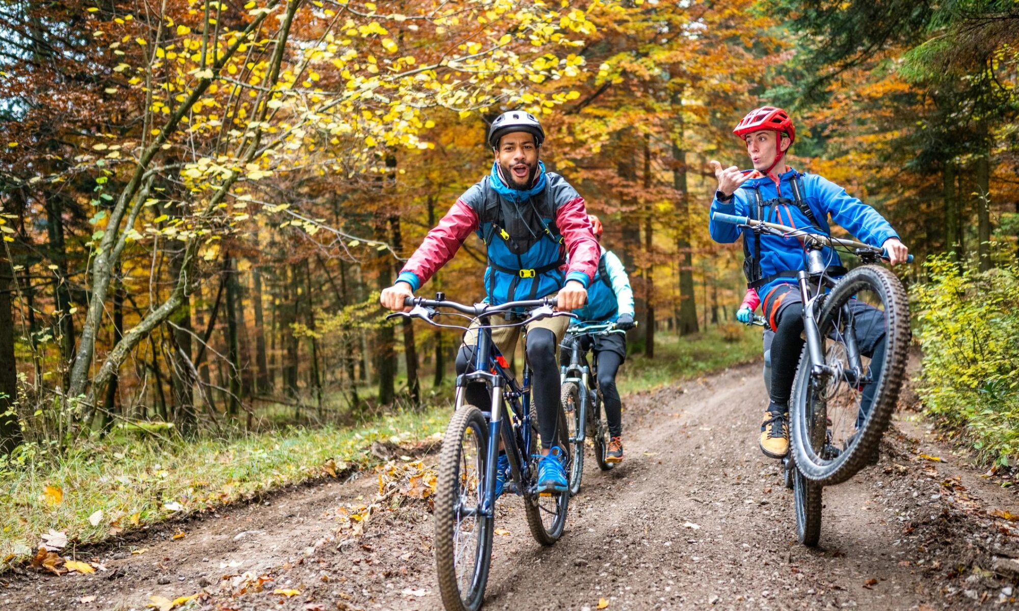 Friends cycling in nature, performing stunts